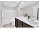 Bright bathroom featuring a double vanity with dark wood cabinets, a toilet and shower/tub combo at 1156 Craigmeade Dr, Morrisville, NC 27560
