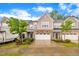A charming townhome with stone accents, a two-car garage, lush landscaping, and a neatly paved driveway on a sunny day at 1156 Craigmeade Dr, Morrisville, NC 27560