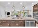 Open-concept kitchen island with granite countertops, a stainless sink, and overlooks the sunny living area at 1156 Craigmeade Dr, Morrisville, NC 27560
