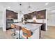 Gourmet kitchen featuring dark cabinetry, a granite island, and modern stainless steel appliances with stylish pendant lighting at 1156 Craigmeade Dr, Morrisville, NC 27560