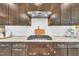 Modern kitchen featuring granite countertops, white subway tile backsplash and stainless steel range hood at 1156 Craigmeade Dr, Morrisville, NC 27560