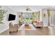 Bright living room with large windows, hardwood floors, contemporary furnishings, and a ceiling fan at 1156 Craigmeade Dr, Morrisville, NC 27560