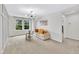 Bright living room featuring a modern chandelier, large window, and comfortable seating at 1156 Craigmeade Dr, Morrisville, NC 27560