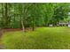 View of the grassy backyard, outbuilding, and access to the elevated back porch at 119 Valleycastle Ct, Clayton, NC 27520
