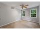 Bedroom with windows, neutral carpet, and a ceiling fan providing a comfortable and well-lit living space at 119 Valleycastle Ct, Clayton, NC 27520