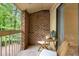 Cozy balcony featuring brick detail, outdoor seating, and sliding glass door access at 1200 Schaub Dr # G, Raleigh, NC 27606