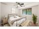 Bright bedroom with large window has iron bed frame, side tables with lamps, and a ceiling fan at 1200 Schaub Dr # G, Raleigh, NC 27606