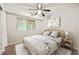 Comfortable bedroom with a ceiling fan has a light wood bed frame, side tables, and window with blinds at 1200 Schaub Dr # G, Raleigh, NC 27606