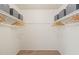 Walk-in closet with neutral carpet, white walls, and gray storage boxes on the upper shelves at 1200 Schaub Dr # G, Raleigh, NC 27606