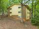 Brick and yellow apartment building surrounded by lush green trees and foliage at 1200 Schaub Dr # G, Raleigh, NC 27606