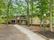 Exterior view of multi-story apartment building surrounded by mature trees and landscaping at 1200 Schaub Dr # G, Raleigh, NC 27606