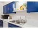 Close-up of kitchen sink with updated faucet and countertops against blue cabinetry at 1200 Schaub Dr # G, Raleigh, NC 27606