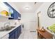 Well-lit kitchen showcases blue cabinets, a white refrigerator, and tiled floors at 1200 Schaub Dr # G, Raleigh, NC 27606