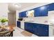 Bright kitchen with blue cabinets, white appliances, and tiled flooring at 1200 Schaub Dr # G, Raleigh, NC 27606