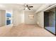 Spacious living room featuring neutral walls, carpeted floor, sliding glass doors, and kitchen view at 1200 Schaub Dr # G, Raleigh, NC 27606