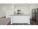 Open concept kitchen features white cabinets, stainless appliances, and a granite-topped island at 1205 Solace Way, Rolesville, NC 27571