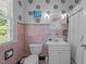 Fun bathroom with a pink and black tile, patterned wallpaper, and decorative accents at 1217 Aycock Ave, Burlington, NC 27215