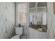 Elegant powder room with patterned wallpaper, marble countertop, and a decorative mirror at 1217 Aycock Ave, Burlington, NC 27215