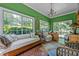 Bright sunroom with large windows, a daybed, and terra cotta tile flooring at 1217 Aycock Ave, Burlington, NC 27215