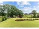 Lush backyard featuring a scenic pond and beautifully landscaped flower beds at 1229 Perry Bluff Dr, Wake Forest, NC 27587