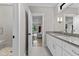 Bright bathroom with white cabinets, gray countertop, tiled shower and entry to the living room at 1229 Perry Bluff Dr, Wake Forest, NC 27587