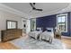 Stylish bedroom boasts hardwood floors, a custom accent wall and a barn door to the ensuite at 1229 Perry Bluff Dr, Wake Forest, NC 27587