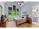 Bright bedroom with a bed, desk, bedside table, three windows and ensuite entrance at 1229 Perry Bluff Dr, Wake Forest, NC 27587