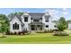 Beautiful two story home with manicured lawn, dark window trim, and covered porch at 1229 Perry Bluff Dr, Wake Forest, NC 27587