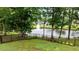 Scenic pond featuring a fountain, surrounded by mature trees and well-maintained landscaping at 1229 Perry Bluff Dr, Wake Forest, NC 27587