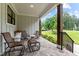 Cozy covered porch with stone flooring and comfortable seating arrangement at 1229 Perry Bluff Dr, Wake Forest, NC 27587