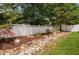 Landscaped backyard featuring a decorative white fence, rock drainage and mulch bed at 128 Low Country Ct, Morrisville, NC 27560