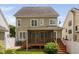 Exterior backyard view featuring a screened porch, back of house, and lush green lawn at 128 Low Country Ct, Morrisville, NC 27560