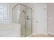 Bright bathroom featuring a glass-enclosed shower and a tiled surround soaking tub at 128 Low Country Ct, Morrisville, NC 27560