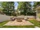 Backyard firepit with stone seating, lush lawn, and a secure white fence at 128 Low Country Ct, Morrisville, NC 27560