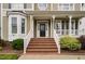 Inviting front porch with brick steps, white railings, and decorative columns at front door at 128 Low Country Ct, Morrisville, NC 27560