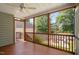 Inviting screened porch with wooden floors, ceiling fan, and view of the firepit area at 128 Low Country Ct, Morrisville, NC 27560