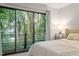 Bright bedroom with a sliding door overlooking a lush bamboo forest and patio at 130 E Longview St # Apt S, Chapel Hill, NC 27516