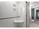 Updated shower featuring subway tile surround, built-in shelving, and glass door at 130 E Longview St # Apt S, Chapel Hill, NC 27516