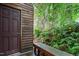 Side entrance with wood siding, an inviting wooden bench, and lush greenery, perfect for relaxation at 130 E Longview St # Apt S, Chapel Hill, NC 27516