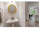 Powder room with pedestal sink, gold-framed mirror, and neutral decor at 1312 Stonemoor Ct, Raleigh, NC 27606