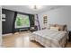 Cozy bedroom featuring hardwood floors, a queen bed, and a window with natural light at 1312 Stonemoor Ct, Raleigh, NC 27606