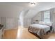 Bedroom with light wood floors, pitched ceilings, neutral colors and a comfortable bed with gray and white quilt at 1312 Stonemoor Ct, Raleigh, NC 27606