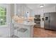 Bright kitchen features white cabinets, stainless steel appliances, marble countertops, and a cozy breakfast bar at 1312 Stonemoor Ct, Raleigh, NC 27606