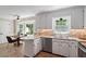 Open kitchen with stainless appliances, stone countertops, white cabinets, breakfast nook, and natural light at 1312 Stonemoor Ct, Raleigh, NC 27606
