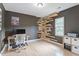 A well-lit home office features light wood floors, modern desk and chair and unique shelves in the corner at 1312 Stonemoor Ct, Raleigh, NC 27606