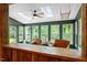 Inviting sunroom featuring a rustic wood bar, multiple windows, and natural lighting from skylights at 1312 Stonemoor Ct, Raleigh, NC 27606
