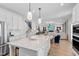 Bright, open kitchen with quartz island, stainless steel appliances, and seamless flow into the living area at 147 Sugar Pine Drive, Franklinton, NC 27525