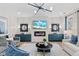 Living room featuring a fireplace, TV, modern light fixture, light wood floors and an accent wall at 147 Sugar Pine Drive, Franklinton, NC 27525