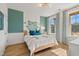 Cozy bedroom with aqua accent wall, wood floors, and lots of natural light from the large window at 148 Sugar Pine Drive, Franklinton, NC 27525