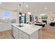 White kitchen featuring an island with a sink, seating, and modern appliances, seamlessly connected to the cozy living area at 148 Sugar Pine Drive, Franklinton, NC 27525